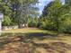 A large backyard with scattered pine needles, surrounded by trees and partially enclosed by a wooden fence at 314 Trace Run, Myrtle Beach, SC 29588