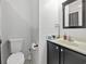 A well-lit bathroom showcasing a toilet, sink, mirror, and neutral color scheme with a dark vanity at 314 Trace Run, Myrtle Beach, SC 29588