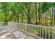 Backyard deck with comfortable seating overlooks a green, lush forest with plenty of trees at 3157 Hermitage Dr., Little River, SC 29566
