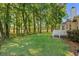 Green backyard with trees. Home has a deck area and a lush lawn at 3157 Hermitage Dr., Little River, SC 29566