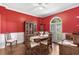 Elegant dining room featuring vibrant red walls, hardwood floors, and classic furnishings at 3157 Hermitage Dr., Little River, SC 29566