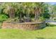 Community entrance featuring a stone sign surrounded by mature palm trees and well-maintained landscaping at 3157 Hermitage Dr., Little River, SC 29566
