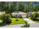 Charming brick home featuring a well-manicured lawn, mature landscaping and a two-car garage at 3157 Hermitage Dr., Little River, SC 29566