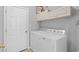 Functional laundry room with white washer and dryer, white cabinets, and a door at 3157 Hermitage Dr., Little River, SC 29566