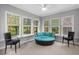 Bright sun room with comfortable seating and large windows offering panoramic views of the outdoors at 3157 Hermitage Dr., Little River, SC 29566