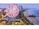 Scenic aerial view of the coastline with a pier and an amusement park with a large ferris wheel at 352 Magnolia Terrace Dr, Myrtle Beach, SC 29579