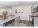 Well-lit kitchen featuring stainless steel appliances, gray cabinets, granite countertops, and modern plank flooring at 384 Rookroost Circle, Conway, SC 29526