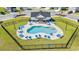 Aerial view of a fenced outdoor pool with lounge chairs and umbrellas surrounded by manicured landscaping at 3968 Hibiscus Dr., Little River, SC 29566