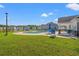 Outdoor pool with lounge chairs and umbrellas surrounded by manicured landscaping and neighborhood homes at 3968 Hibiscus Dr., Little River, SC 29566