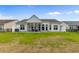 Home featuring a screened in back porch, spacious backyard, and lush green lawn at 4311 Grovecrest Circle, North Myrtle Beach, SC 29582