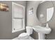 Powder room featuring a pedestal sink, round mirror, window with blind, and artwork, maximizing space at 4311 Grovecrest Circle, North Myrtle Beach, SC 29582