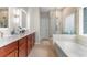 Bathroom with dual sinks, marble countertops, and a glass-enclosed shower at 4311 Grovecrest Circle, North Myrtle Beach, SC 29582