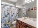 Nautical themed bathroom featuring a vanity with dark wood cabinets, light countertop, and decorative shower curtain at 4311 Grovecrest Circle, North Myrtle Beach, SC 29582