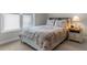 Cozy bedroom features a decorative comforter, side table with lamp, and a window letting in natural light at 4311 Grovecrest Circle, North Myrtle Beach, SC 29582