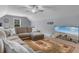 Spacious living room with a large sectional sofa, ceiling fan, and beach view displayed on the TV screen at 4311 Grovecrest Circle, North Myrtle Beach, SC 29582