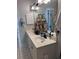 Bathroom featuring dual sinks with black faucets, a white vanity, and white tile floors at 4425 Eastport Blvd. # I-1, Little River, SC 29566