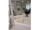Bathroom with a white tiled tub, large mirror, and vanity with decorative items at 4425 Eastport Blvd. # I-1, Little River, SC 29566