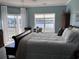 Bedroom with a river view, including large windows, wood floors, a white comforter, and blue walls at 4425 Eastport Blvd. # I-1, Little River, SC 29566
