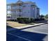 Multi-story condo building with white balconies, professional landscaping, and ample parking at 4425 Eastport Blvd. # I-1, Little River, SC 29566