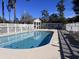 Outdoor pool area with a clear blue pool, white fences, a building with restrooms, and lounge chairs at 4425 Eastport Blvd. # I-1, Little River, SC 29566