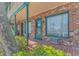 Close-up of the exterior with brick walls, a covered patio, and lush green plants at 4516 Seaview St. # 135, North Myrtle Beach, SC 29582