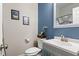 Charming bathroom featuring blue accent wall, modern sink, and decorative mirror at 4697 Farm Lake Dr., Myrtle Beach, SC 29579