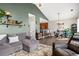 Inviting living room with a comfortable gray sectional sofa, shelves, and an open floor plan to the kitchen at 4697 Farm Lake Dr., Myrtle Beach, SC 29579