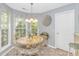 Sunlit dining nook showcases an ornate table set, decorative chandelier, and view of the outdoor greenery at 5 Old Barge Dr., Pawleys Island, SC 29585