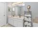 Bathroom featuring double sink vanity, decorative mirrors, and well-organized towel storage at 5 Old Barge Dr., Pawleys Island, SC 29585