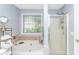 Bright bathroom featuring a soaking tub with tile surround and a glass-enclosed shower at 5 Old Barge Dr., Pawleys Island, SC 29585