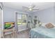 Cozy bedroom with a large window, ceiling fan, light blue walls, and neutral decor at 5 Old Barge Dr., Pawleys Island, SC 29585