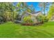 Back exterior of home featuring green lawn and mature trees at 5 Old Barge Dr., Pawleys Island, SC 29585