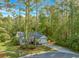 Charming single-story home with manicured lawn, driveway, and surrounded by tall trees at 5 Old Barge Dr., Pawleys Island, SC 29585
