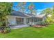 Well-maintained backyard with lush green grass, a patio area, an enclosed sunroom, and mature landscaping at 5 Old Barge Dr., Pawleys Island, SC 29585