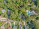 Aerial view of a community with mature trees, winding roads, and a pool with a hot tub area at 5 Old Barge Dr., Pawleys Island, SC 29585