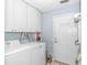 Well-lit laundry room with washer, dryer, overhead cabinets, and convenient exterior access door at 5 Old Barge Dr., Pawleys Island, SC 29585