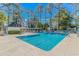 Large community pool with lounge chairs, a covered pergola area, and mature trees providing shade at 5 Old Barge Dr., Pawleys Island, SC 29585