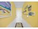 Bright hallway with yellow walls, wainscoting, and coastal decorations lead to the front door at 500 Fairway Village Dr. # 7-C, Myrtle Beach, SC 29588