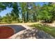 Expansive backyard featuring mature trees, a gravel driveway, and a brick area, perfect for outdoor activities at 509 S Rosemary Ave., Andrews, SC 29510
