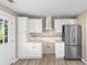 Modern kitchen featuring white cabinets, stainless steel appliances, granite countertops, and wood-look flooring at 509 S Rosemary Ave., Andrews, SC 29510