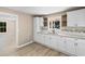 Well-lit kitchen boasts white cabinets, granite countertops, a modern sink, and stylish wood-look flooring at 509 S Rosemary Ave., Andrews, SC 29510