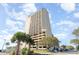Low angle of high-rise condo building with balconies and parking garage under a partly cloudy sky at 5523 N Ocean Blvd. # 1201, Myrtle Beach, SC 29577