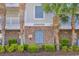 Close-up of condo building detail with signage, sprinker, brick accents, and green shrubs at 5801 Oyster Catcher Dr. # 1621, North Myrtle Beach, SC 29582