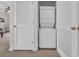Compact laundry area with a stacked washer and dryer unit, enclosed by white doors at 5801 Oyster Catcher Dr. # 1621, North Myrtle Beach, SC 29582