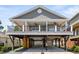 Coastal home featuring a covered porch, ground-level parking, and durable gray siding at 6001- 5432 S Kings Highway, Myrtle Beach, SC 29575