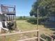 Wide open backyard with wooden deck, green grass, trees, and a view of the marsh in the distance at 640 Willowbank Rd., Georgetown, SC 29440
