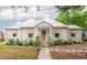 Charming home featuring a metal roof, brick walkway, yellow door, and lovely landscaping at 640 Willowbank Rd., Georgetown, SC 29440