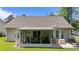 Rear view of home with screened patio, well-kept lawn, and backyard at 6465 Royal Pine Dr., Myrtle Beach, SC 29588