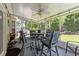 Enclosed patio with outdoor dining set, fan, and a view of the landscaped backyard at 6465 Royal Pine Dr., Myrtle Beach, SC 29588