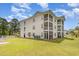 Exterior of the multi-story building with screened porches and well-maintained landscaping at 673 Tupelo Ln. # G, Longs, SC 29568